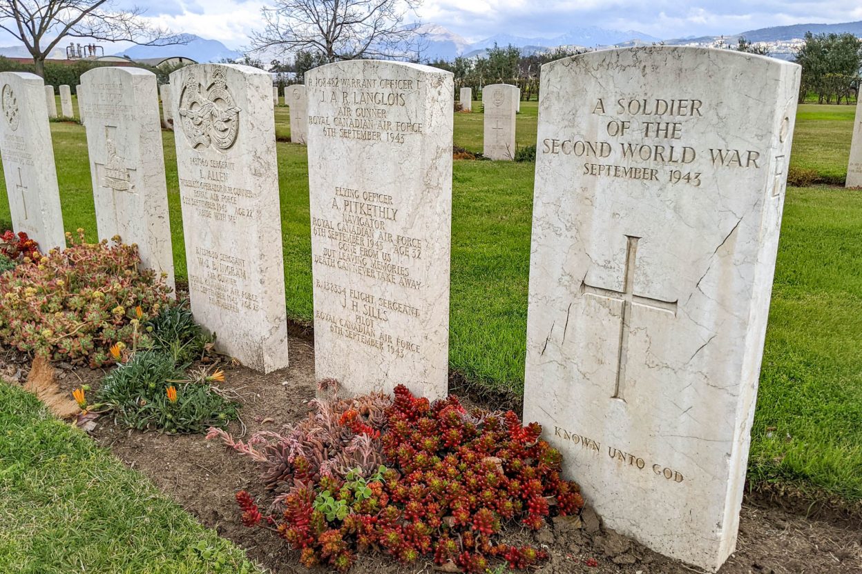 headstones with red flowers in front at salerno war cemetery