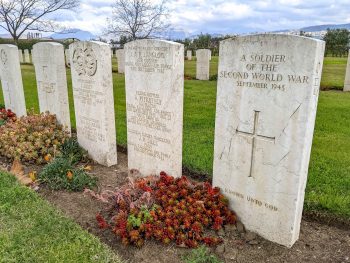 headstones with red flowers in front at salerno war cemetery