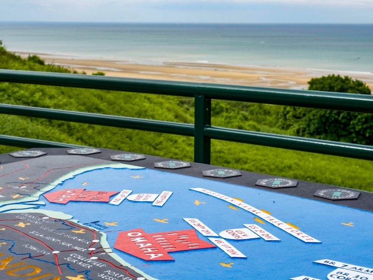 informational placard of the dday invasion in front of a beach