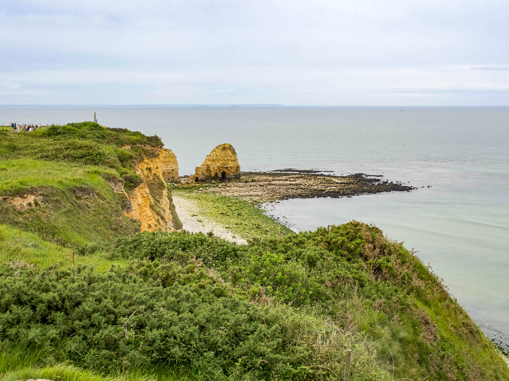 grass-covered cliffs next to a gray ocean
