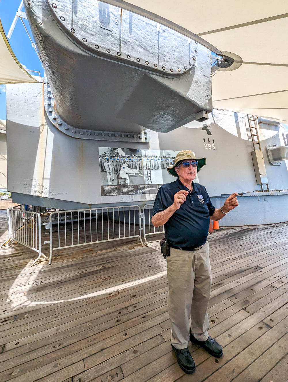 a man giving a tour on a battleship deck