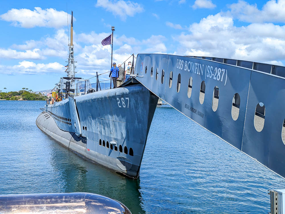 view of the front of a submarine sticking out of the water and the gangplank to get to it