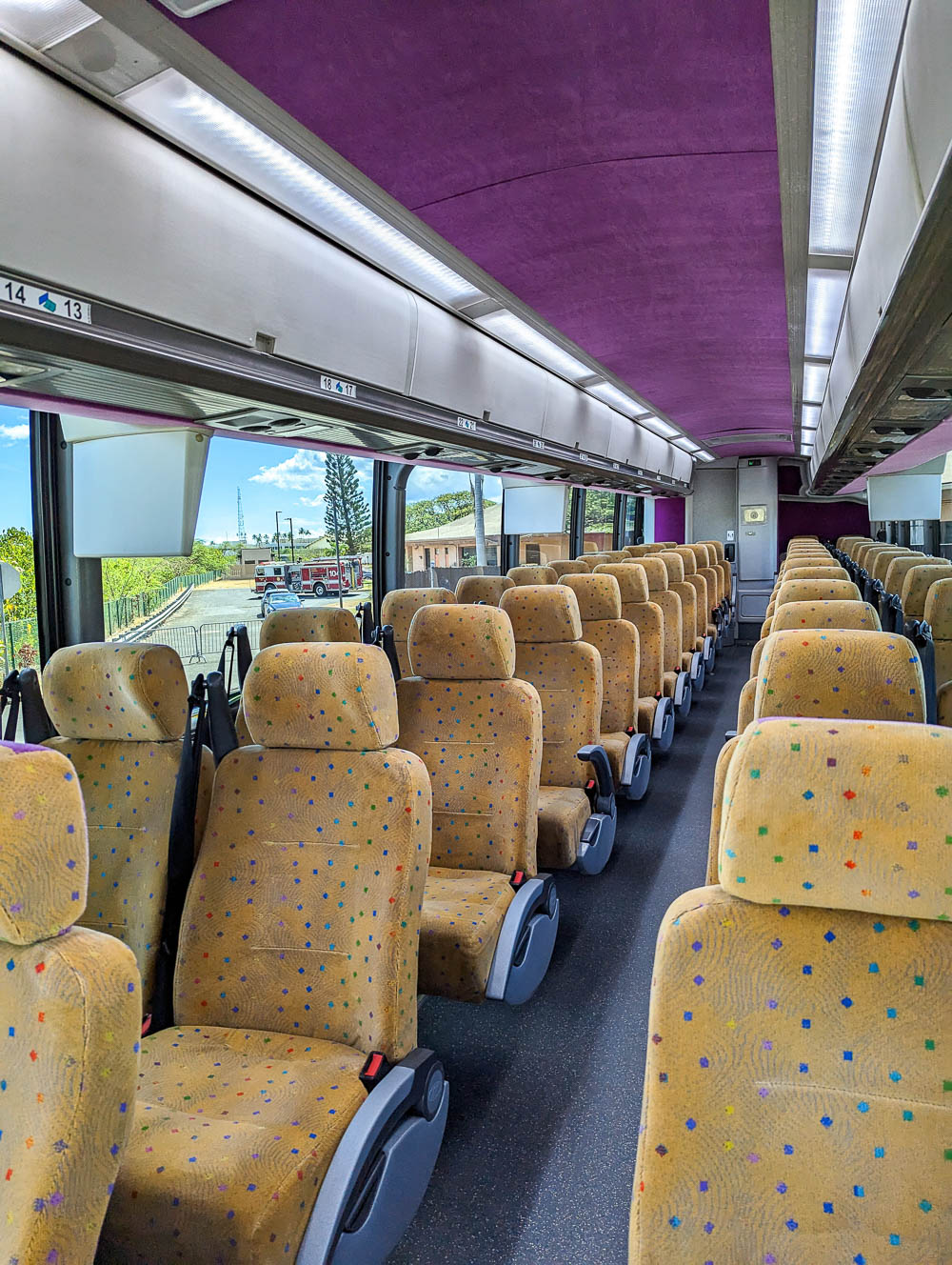 an empty shuttle but with purple ceiling and yellow seats at the pearl harbor visitor center