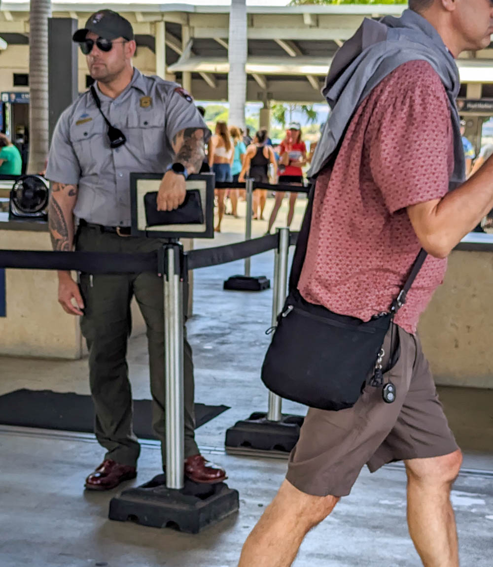park guard holding a small bag at the entrance to a visitor center