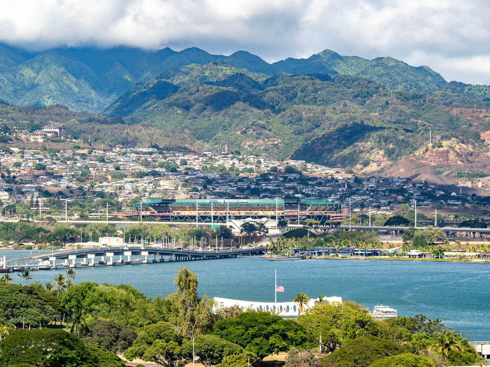 overhead view of the uss arizona memorial with green mountains in the background