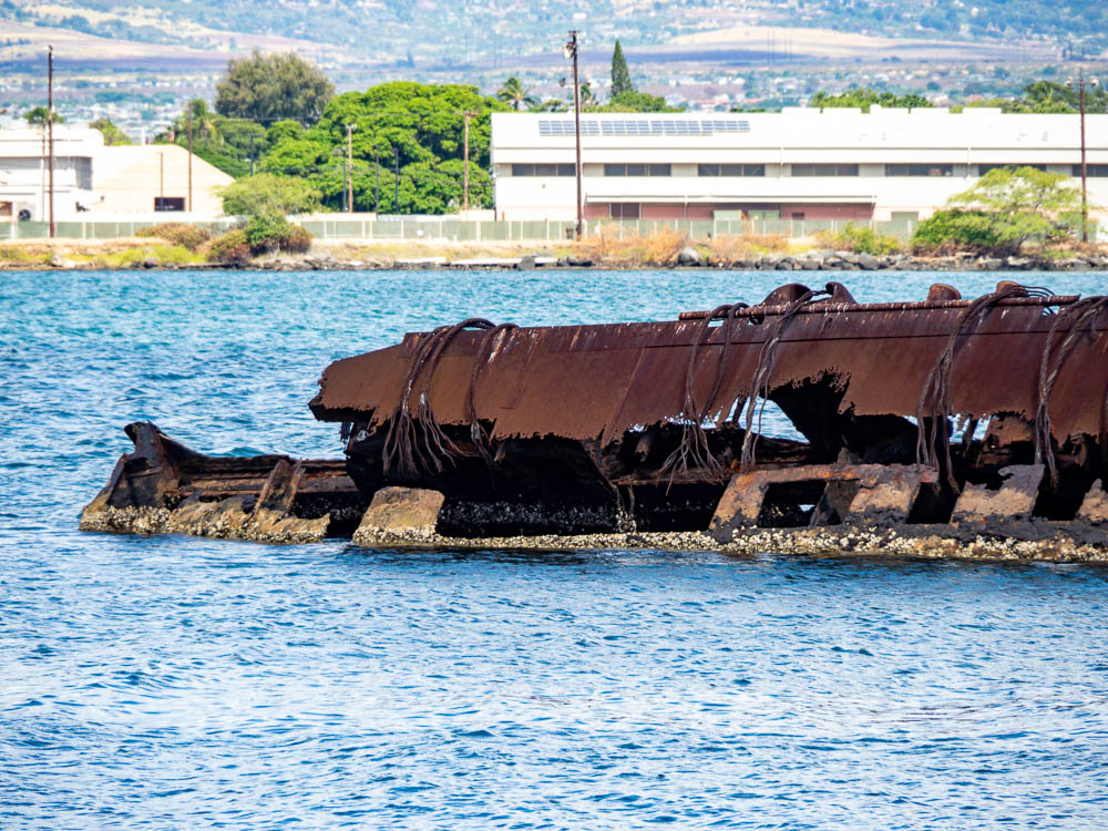 the rusted remains of a battleship sticking out of the ocean