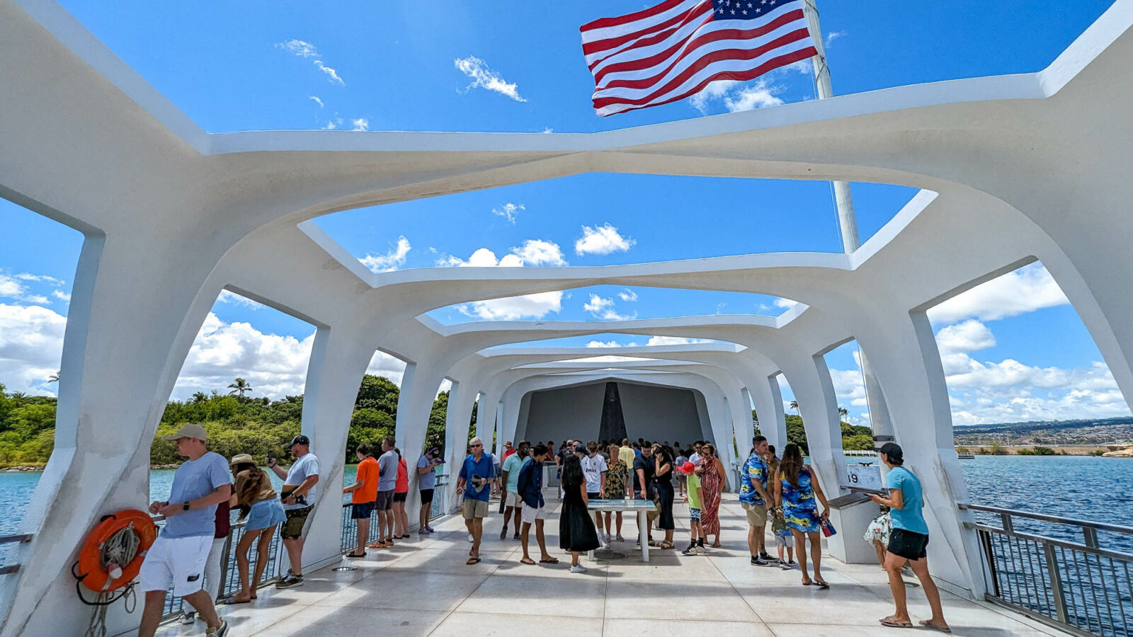 people on board a white memorial over the water under an american flag