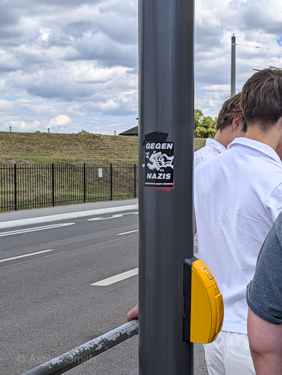 sticker on a pole that says "gegen nazis"