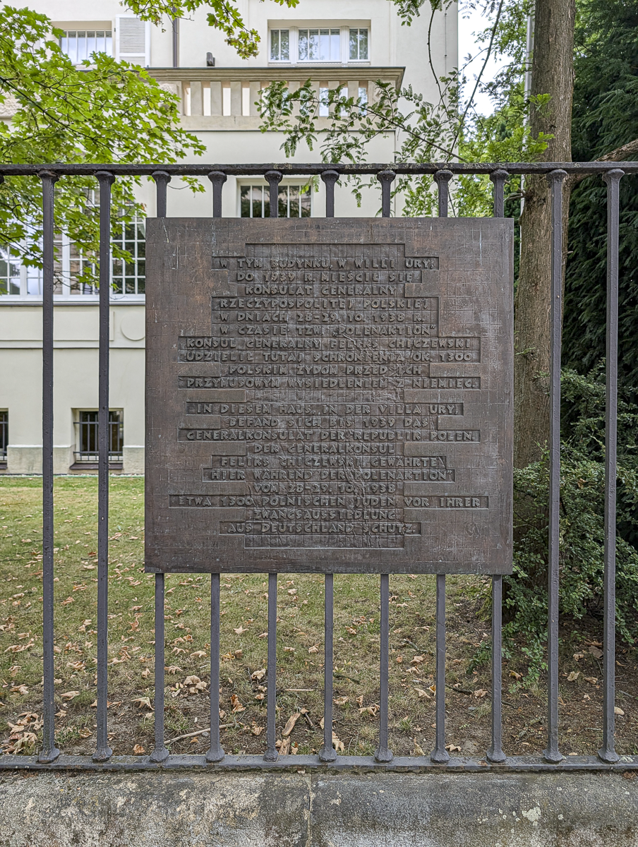 large brown plaque on an iron fence