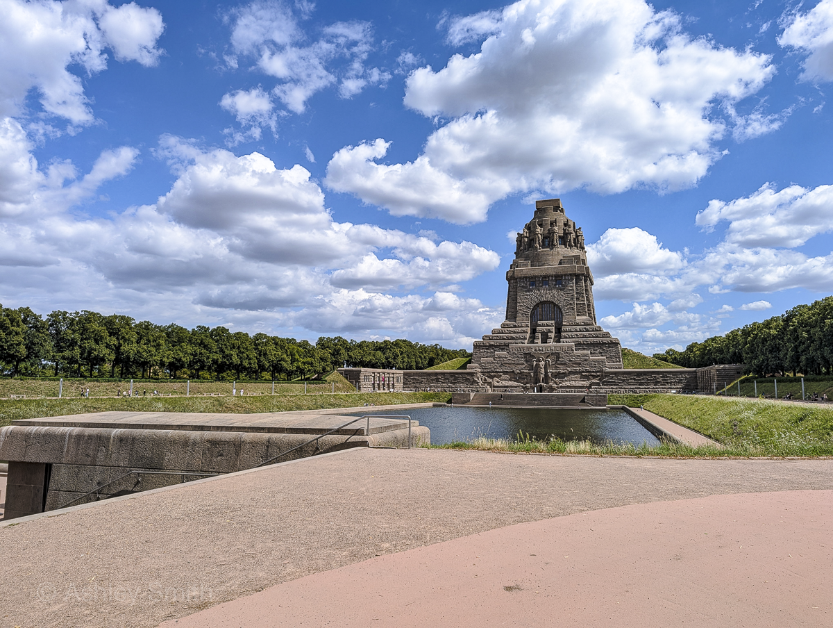 large brown monument behind a pond